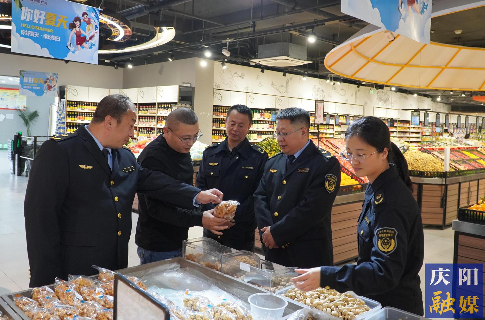 市县两级市场监管部门执法人员检查合水某商超干果类食品标识标签。