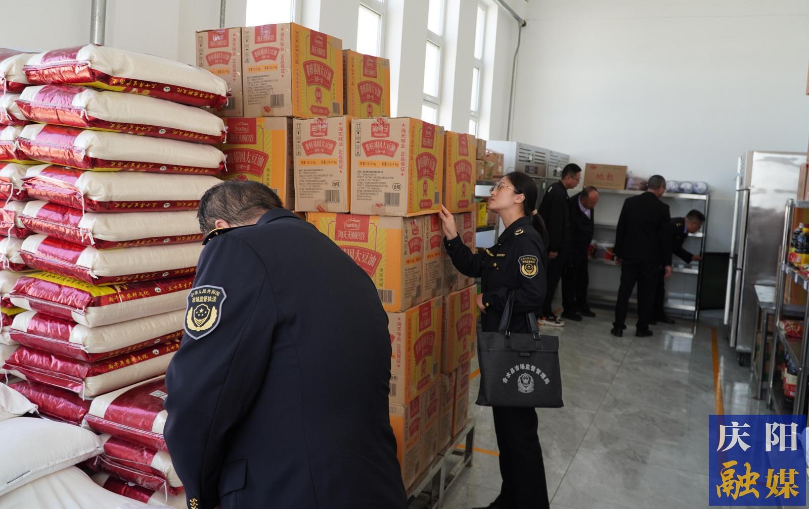 市县两级市场监管部门执法人员检查合水一中食堂仓库食品物料储存管理情况。